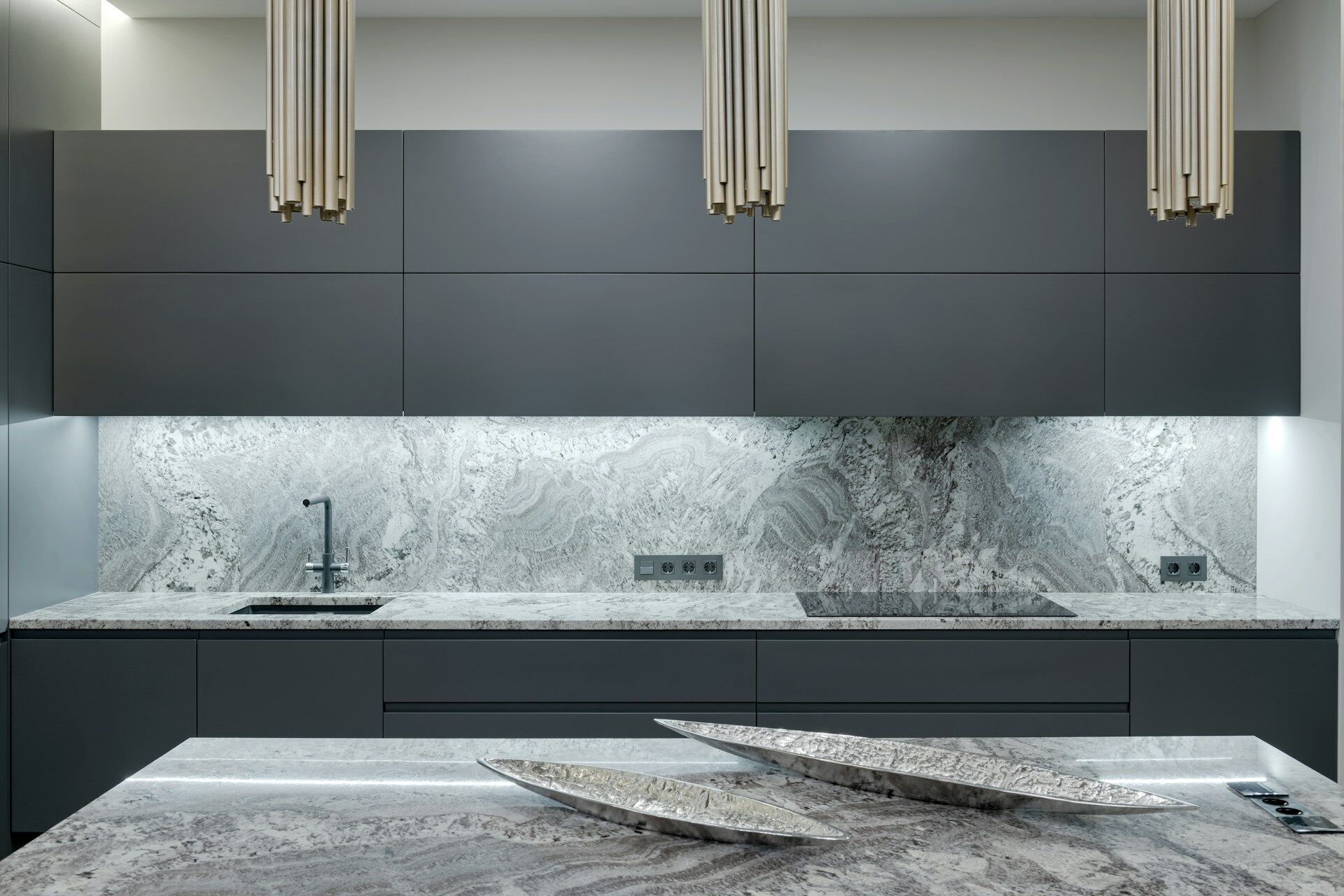Modern kitchen with granite countertop, backsplash, and gray cabinets