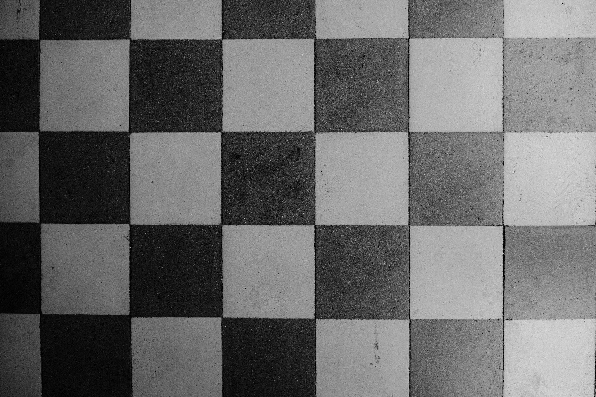 Black and white checkerboard tile pattern with alternating dark and light squares