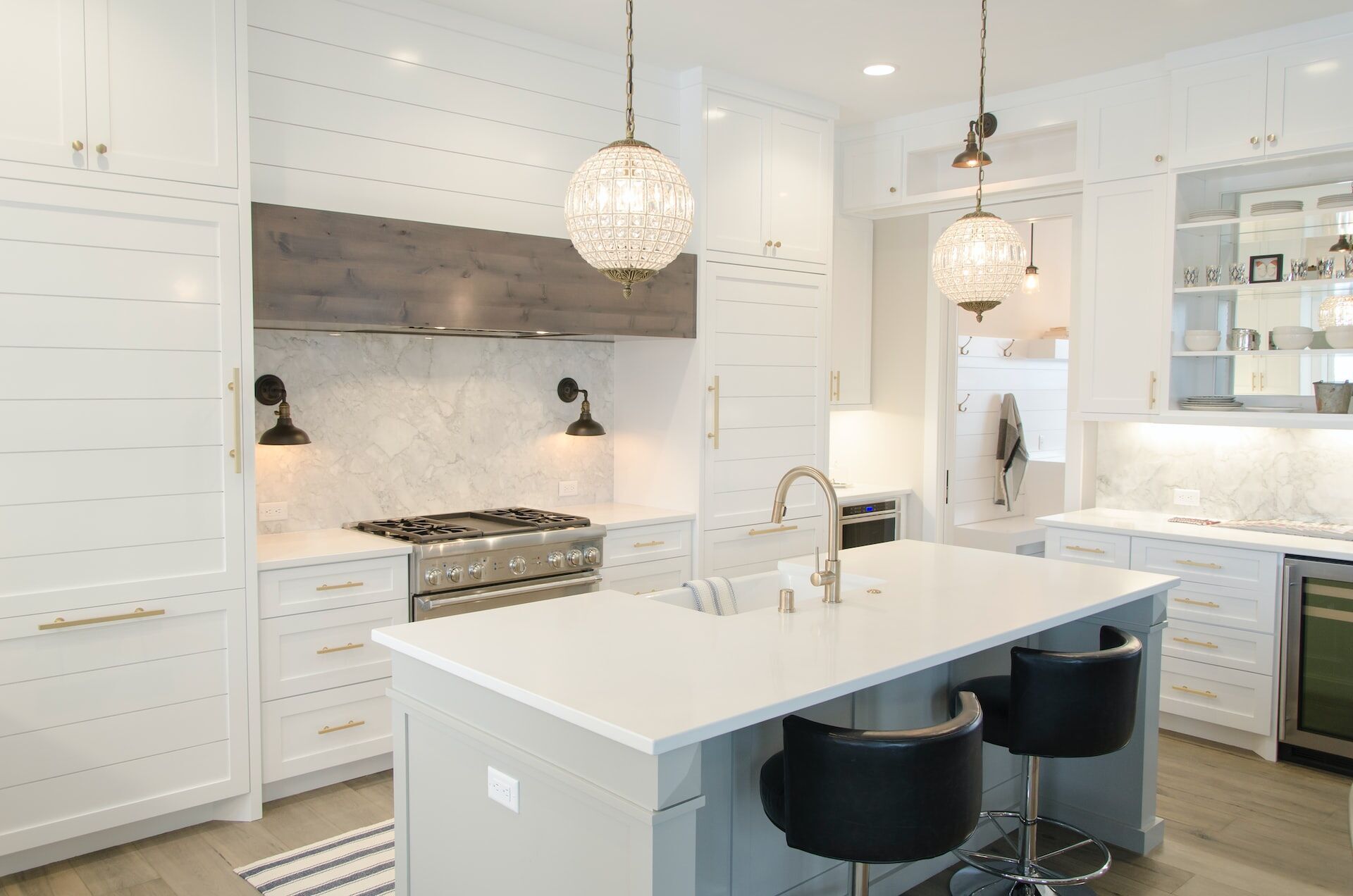 Modern kitchen with white cabinets, large island, and marble backsplash