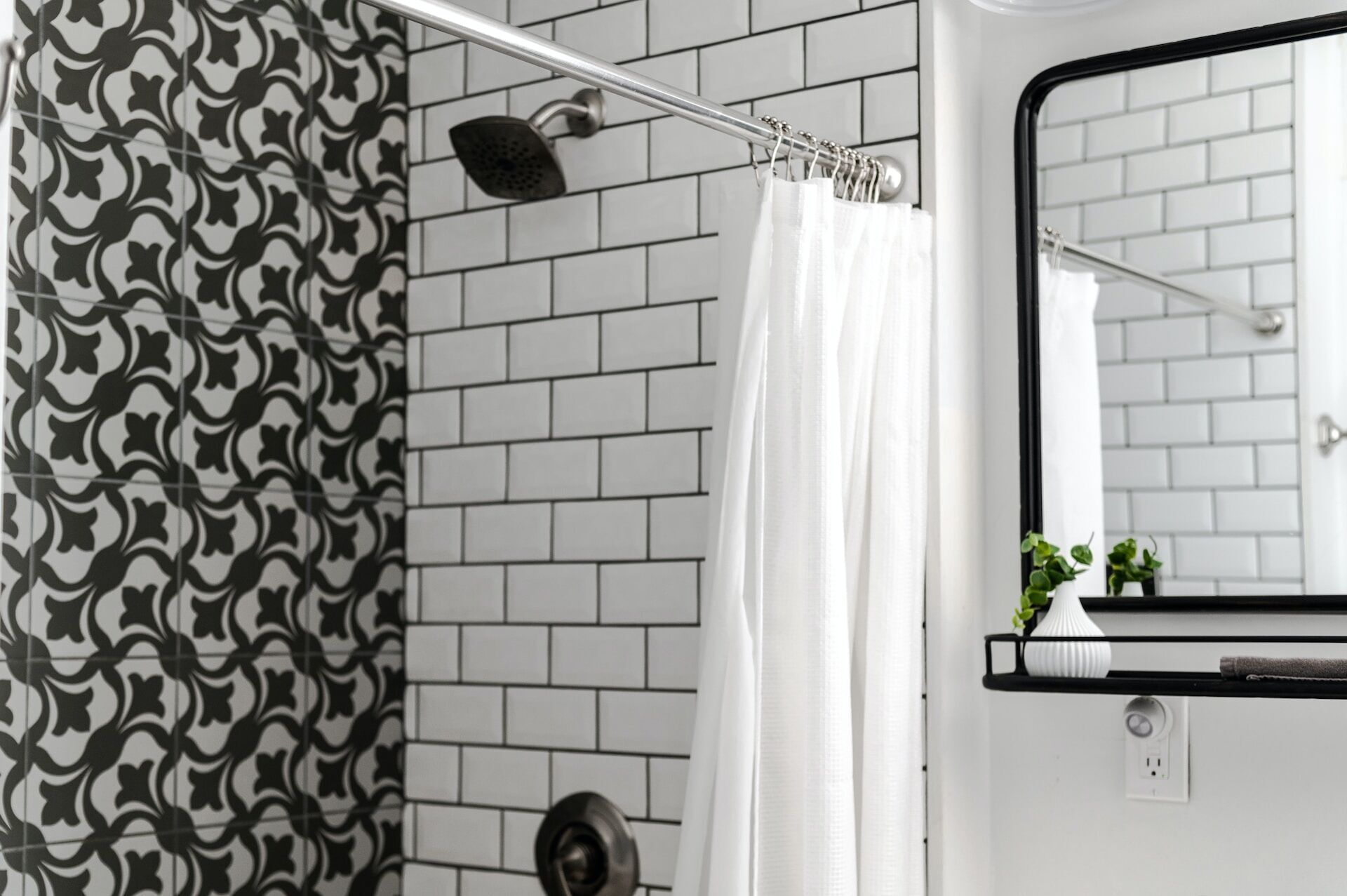 Bathroom with patterned tile wall, subway tile wall, showerhead, and white curtain