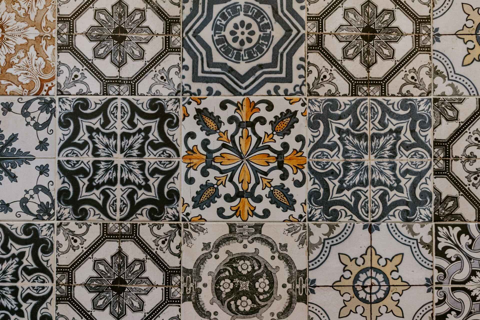 Close-up of intricately patterned tiles with floral and geometric designs in blue, yellow, and black