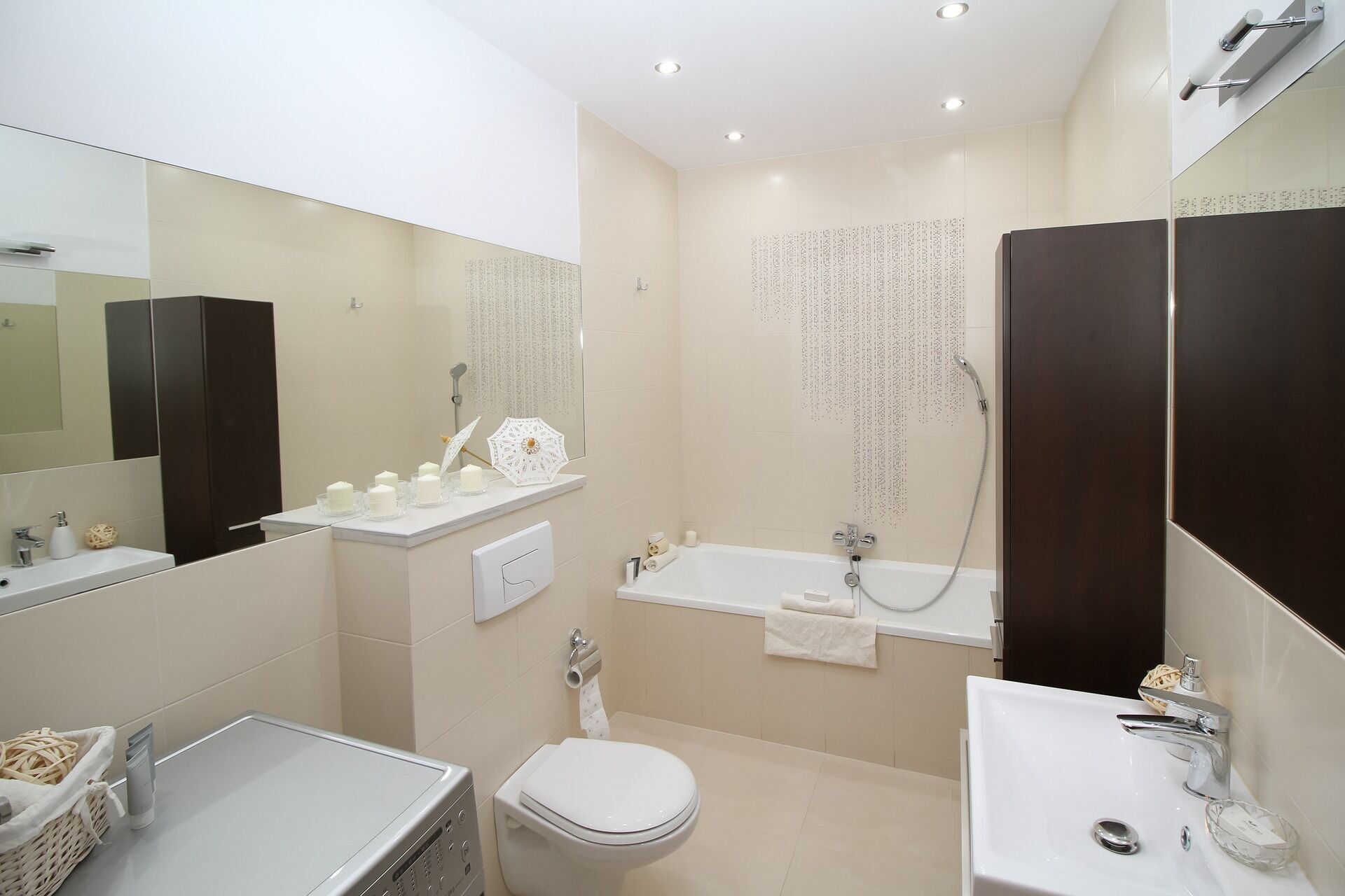 Modern bathroom with beige tiles, bathtub, wall-mounted toilet, and dark wood accents
