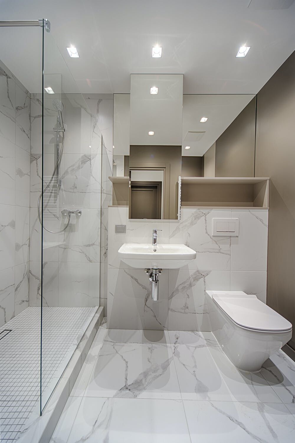 Bathroom with marble-patterned porcelain tiles, walk-in shower, sink, and toilet