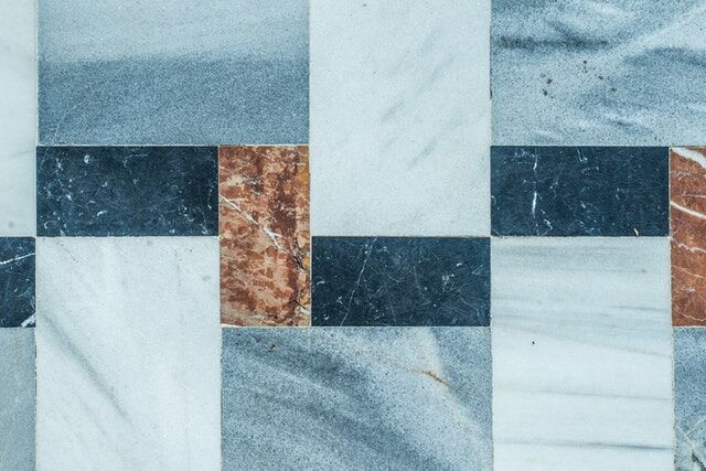 Close-up of blue, brown, and white tiles in a geometric pattern, showcasing diverse textures