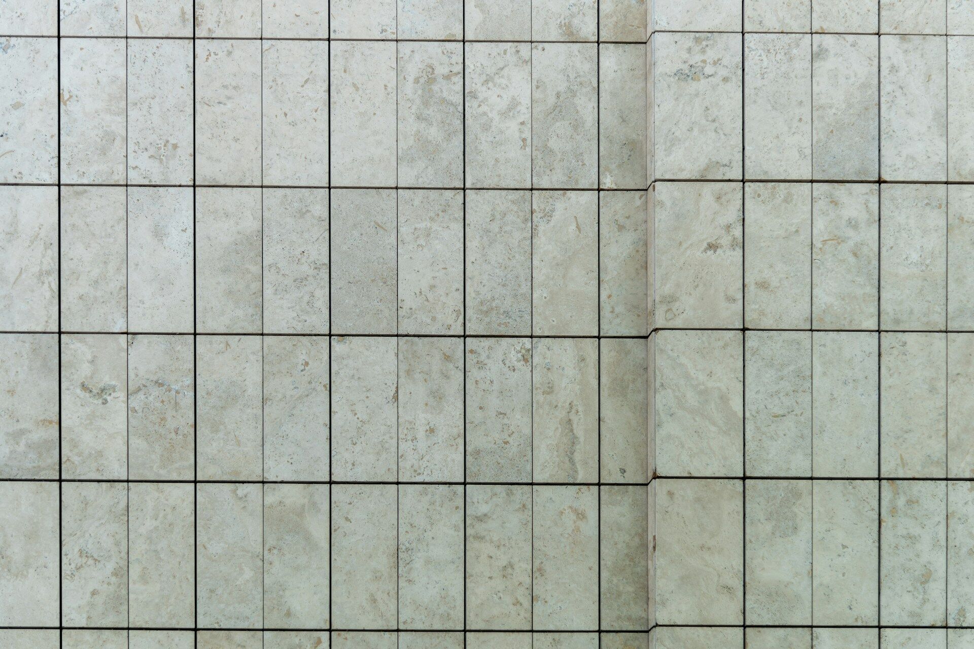Close-up view of a wall with light-colored rectangular tiles in a grid pattern