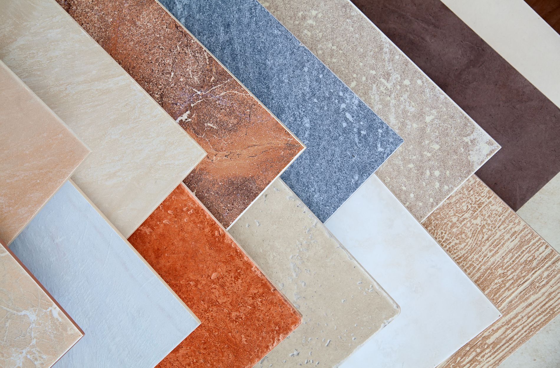 Assorted ceramic tiles in various colors and textures arranged in a fan pattern