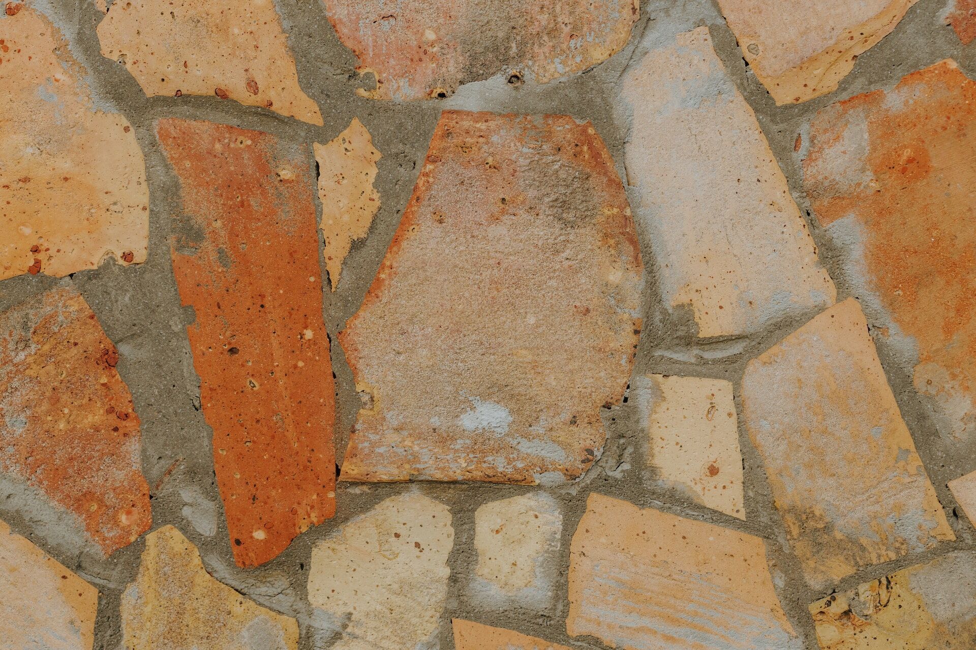Close-up of natural stone flooring with irregular shapes and earthy colors set in grout