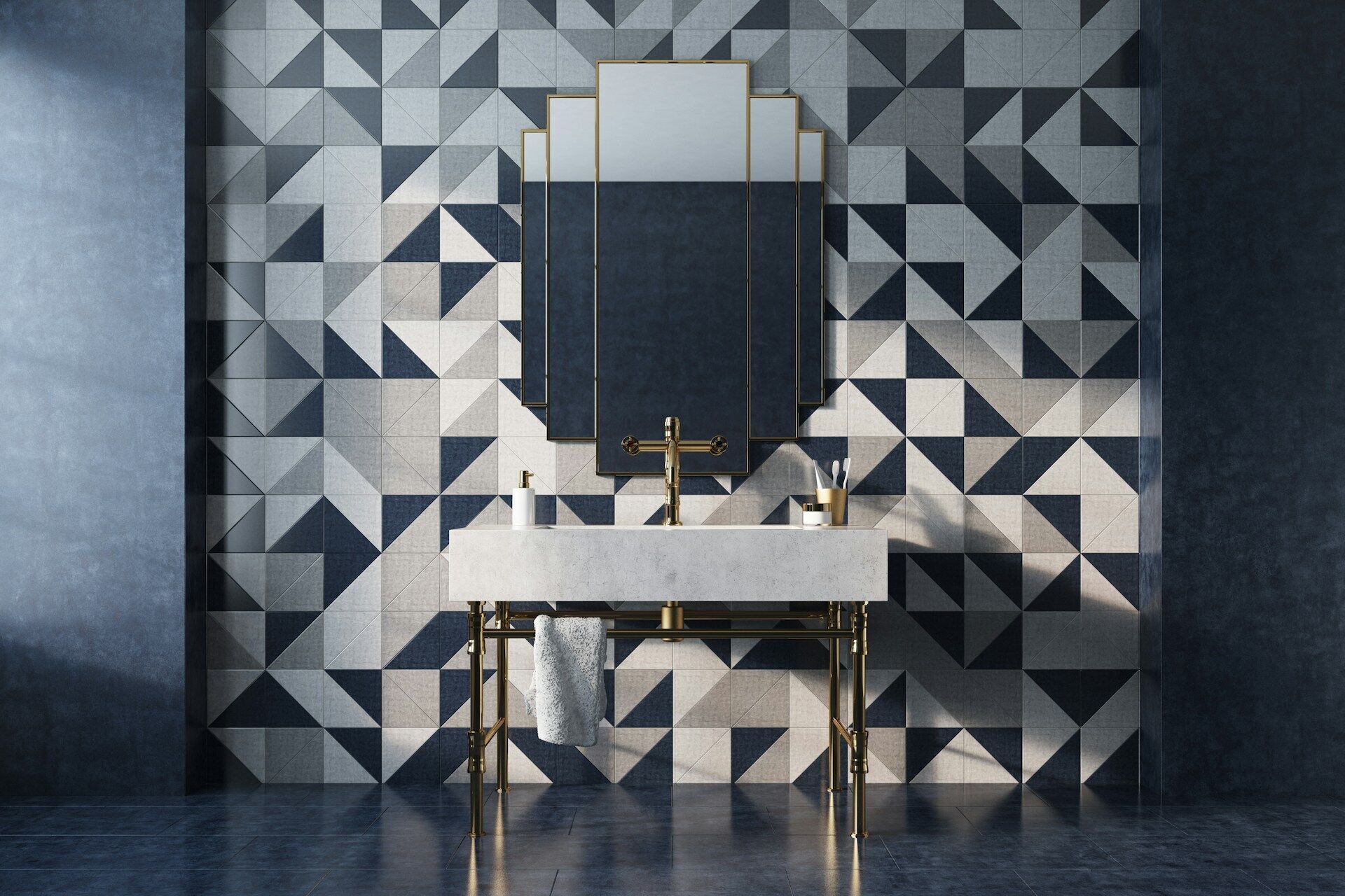 Bathroom with geometric blue and gray tile wall, gold mirror, and white sink
