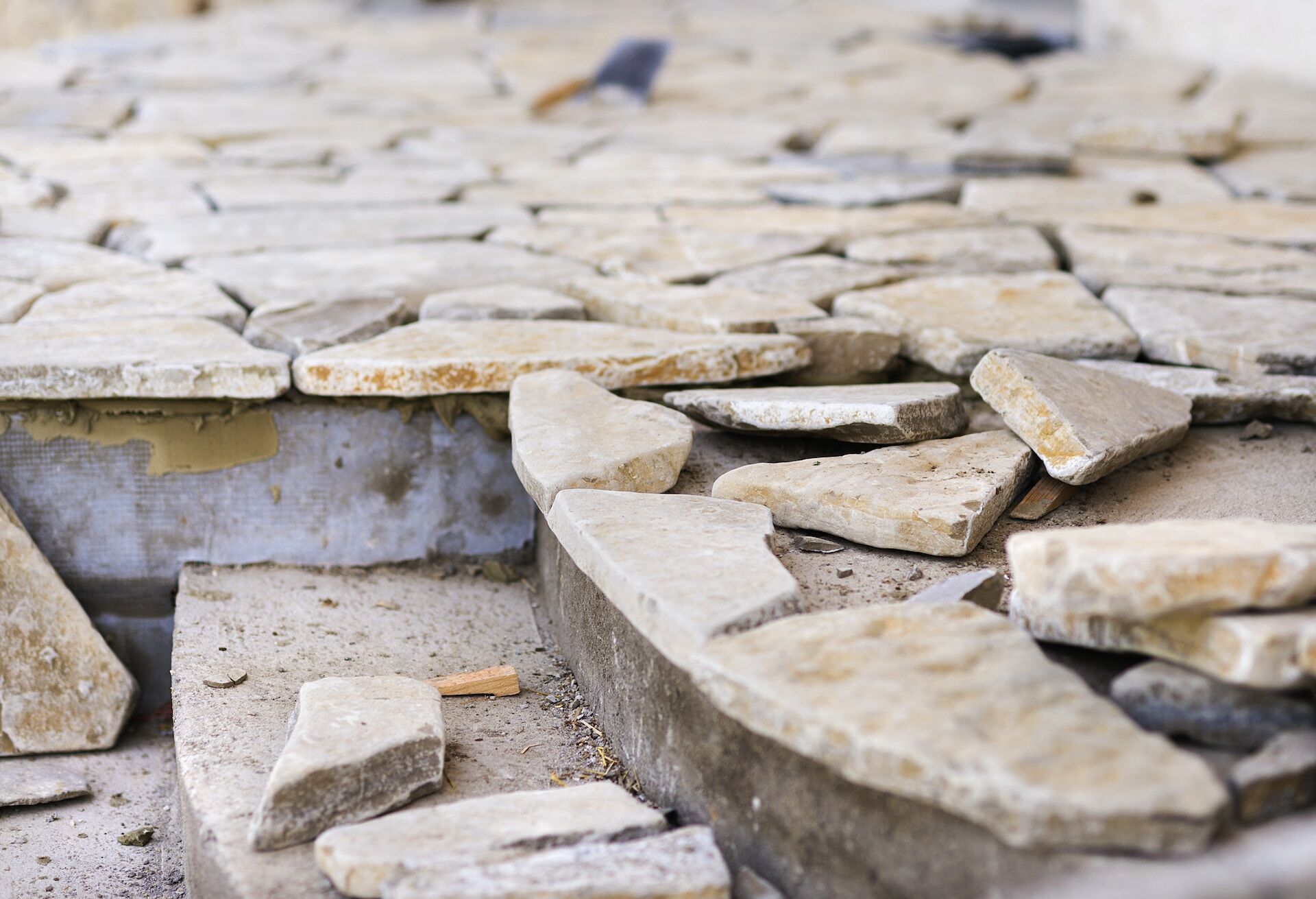 Close-up of irregularly shaped natural stone tiles laid on a surface, highlighting texture and color variations