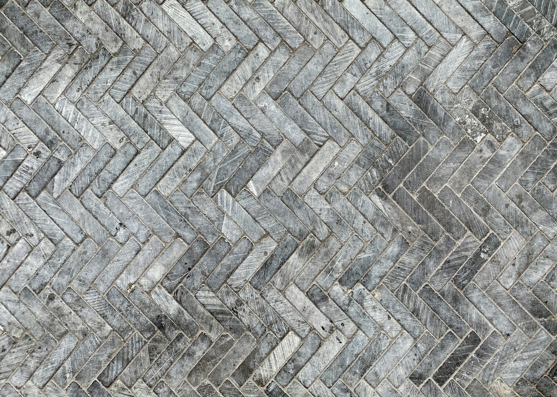 Close-up of gray herringbone pattern floor tile with textured surface