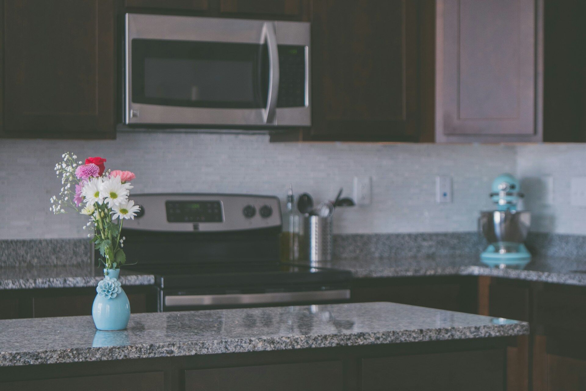 Kitchen featuring a granite countertop, stainless steel appliances, and a vase with flowers