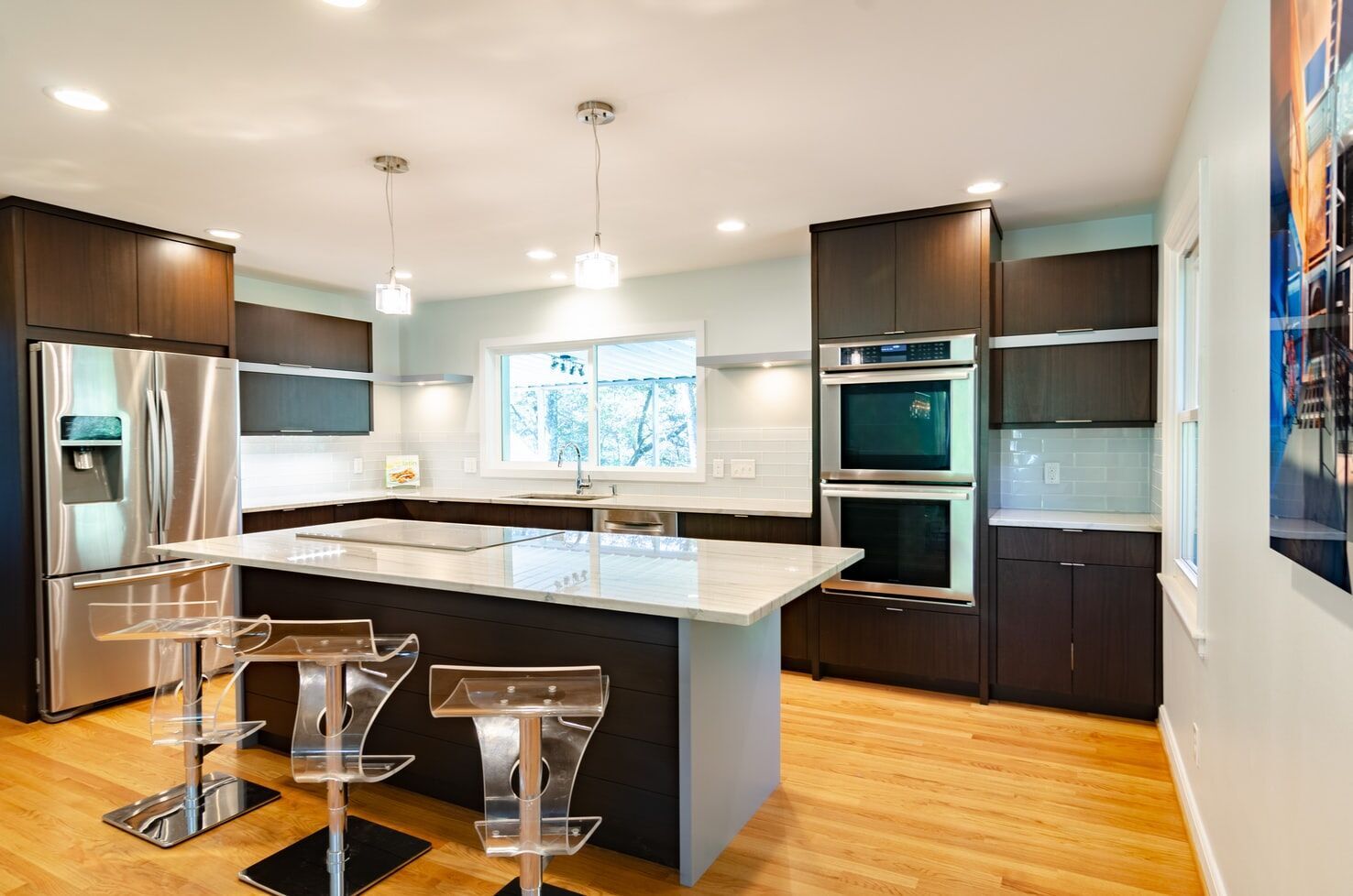 Modern kitchen with marble island, dark wood cabinets, and stainless steel appliances