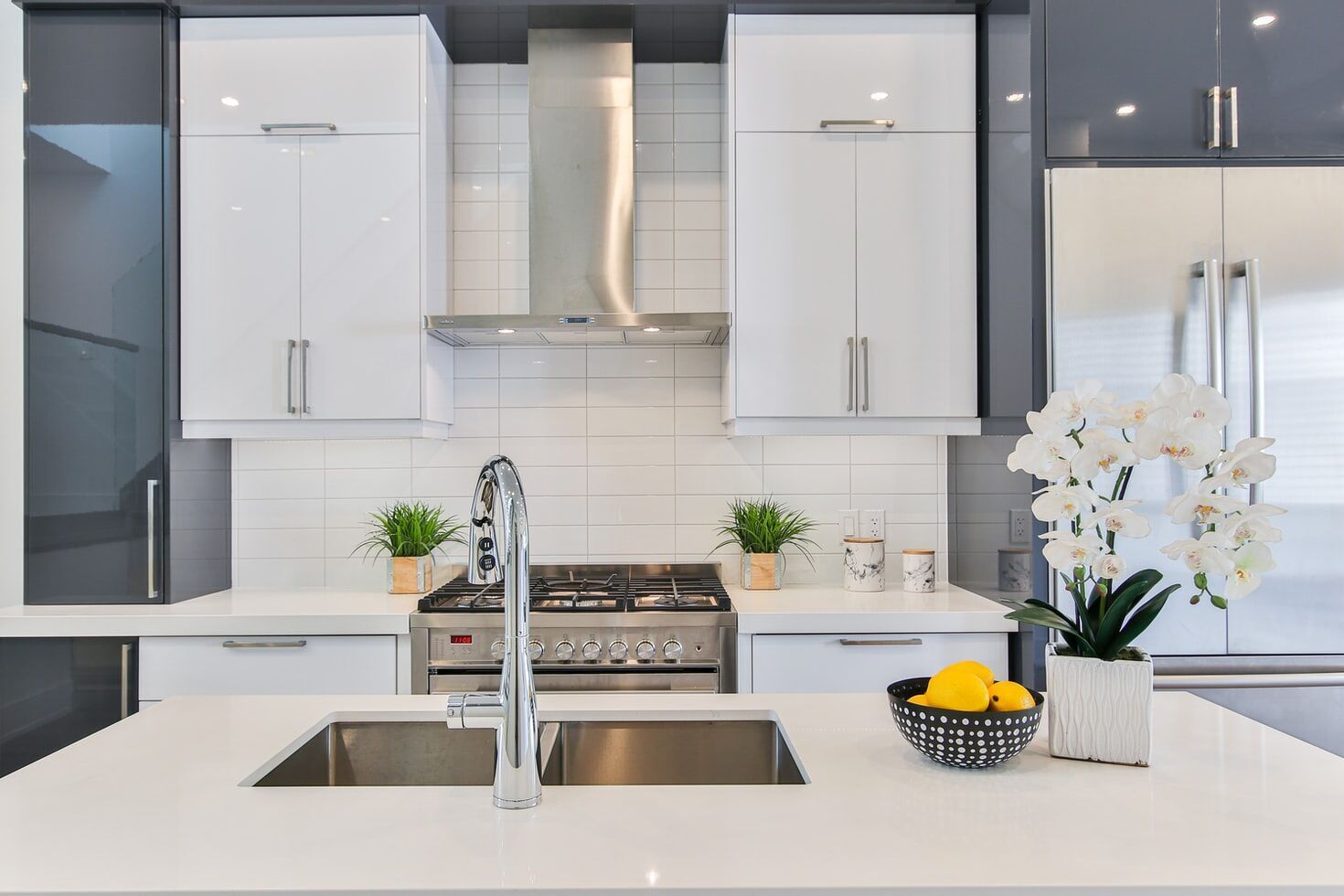 Modern kitchen with white cabinets, stainless steel stove, and white tile backsplash