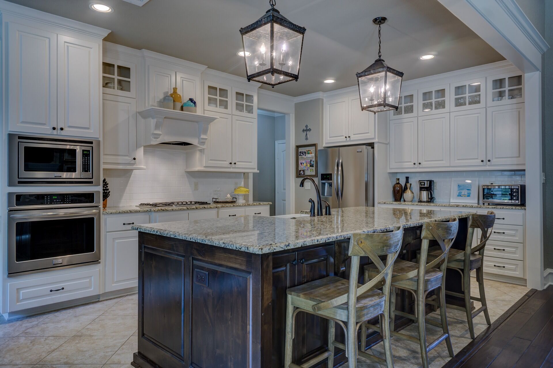 Modern kitchen featuring white cabinets, granite island, and stainless steel appliances