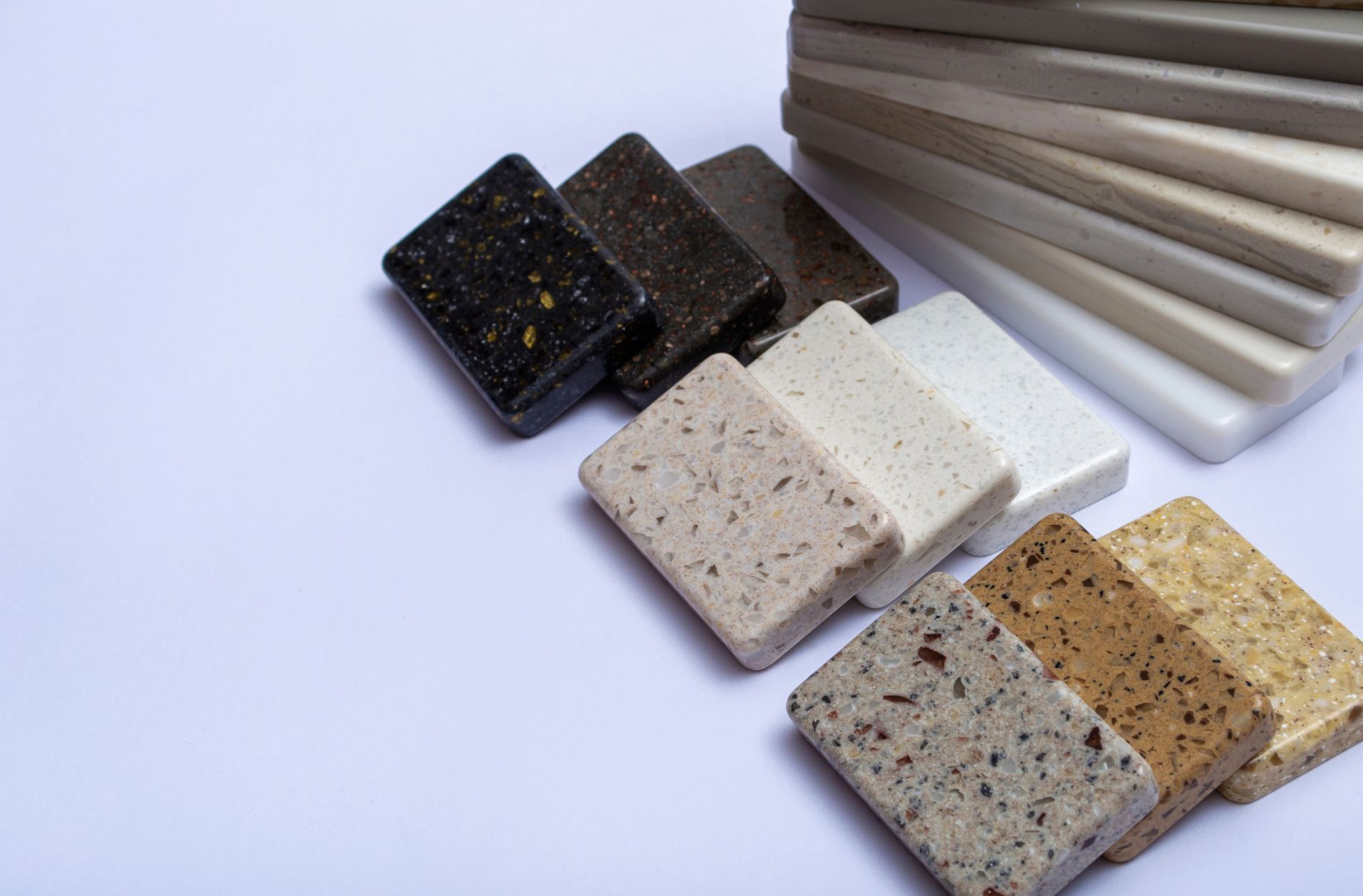 Assorted stone and marble sample tiles in various colors and textures on a white background