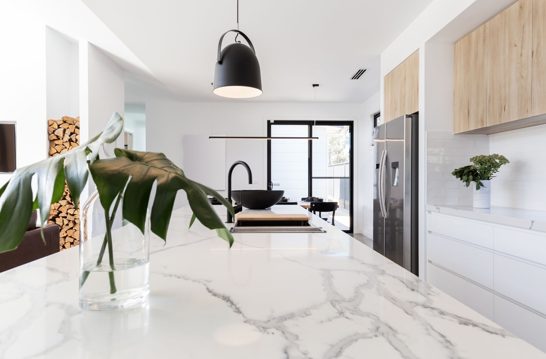 Modern kitchen featuring a white marble countertop, wooden cabinets, and stainless steel appliances