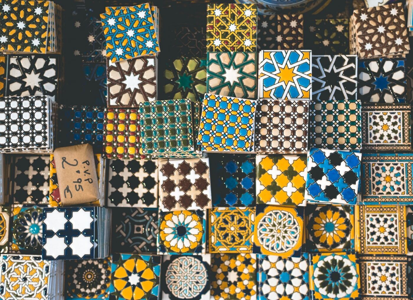A variety of colorful mosaic tiles with intricate geometric designs in blue, yellow, and white