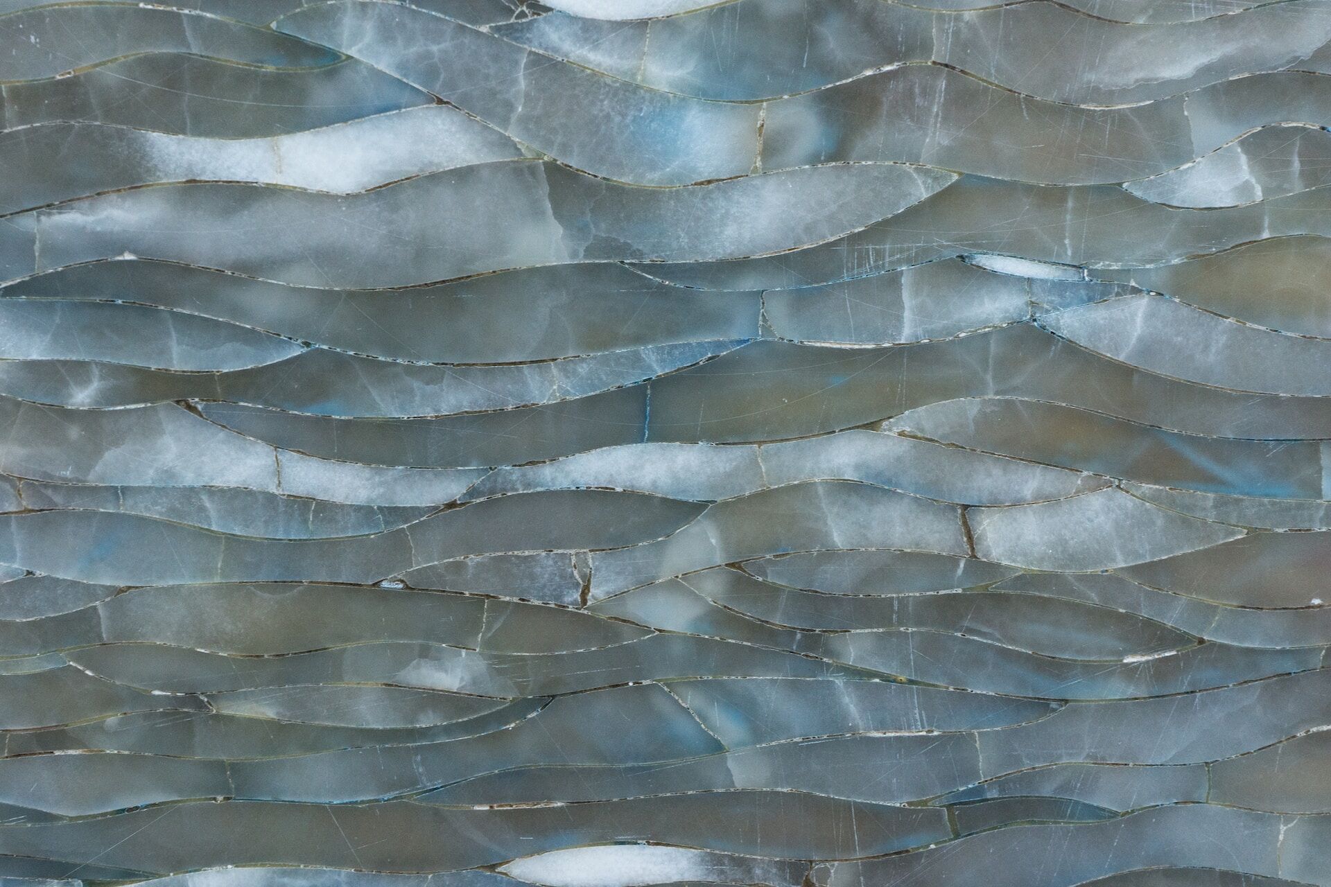 Close-up of a blue quartz surface with wavy patterns and a polished finish
