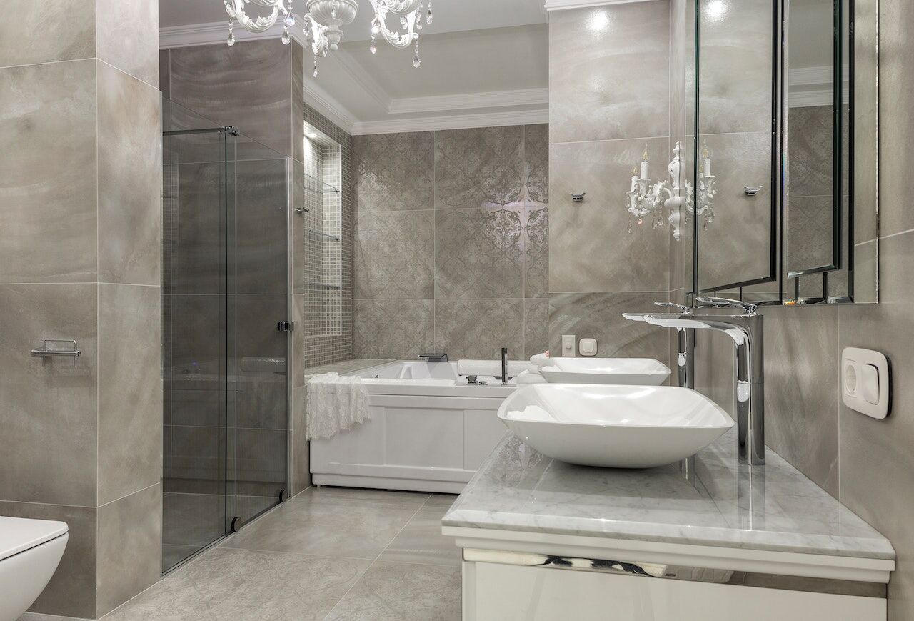 Modern bathroom with double vanity, vessel sinks, glass shower, and large-format tiles