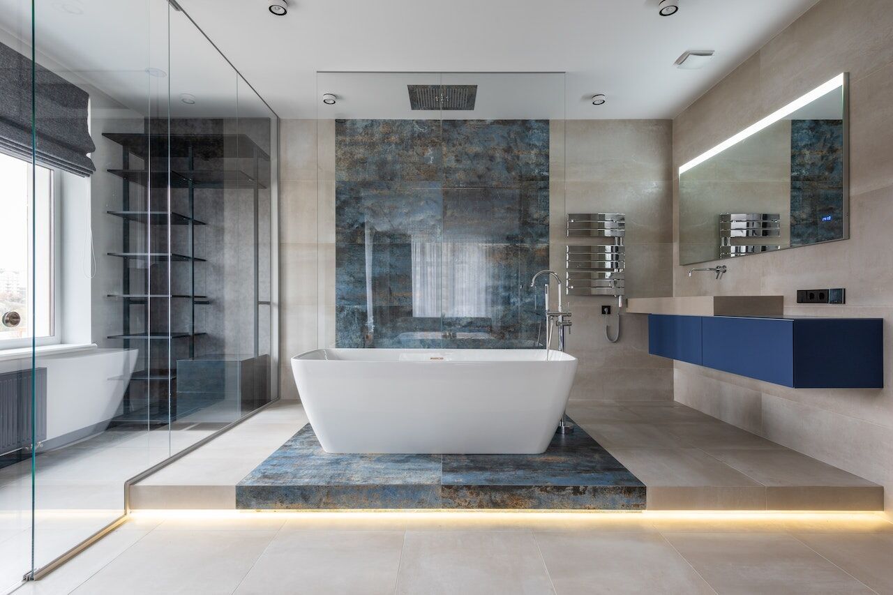 Modern bathroom with freestanding tub, blue stone platform, and glass shower enclosure