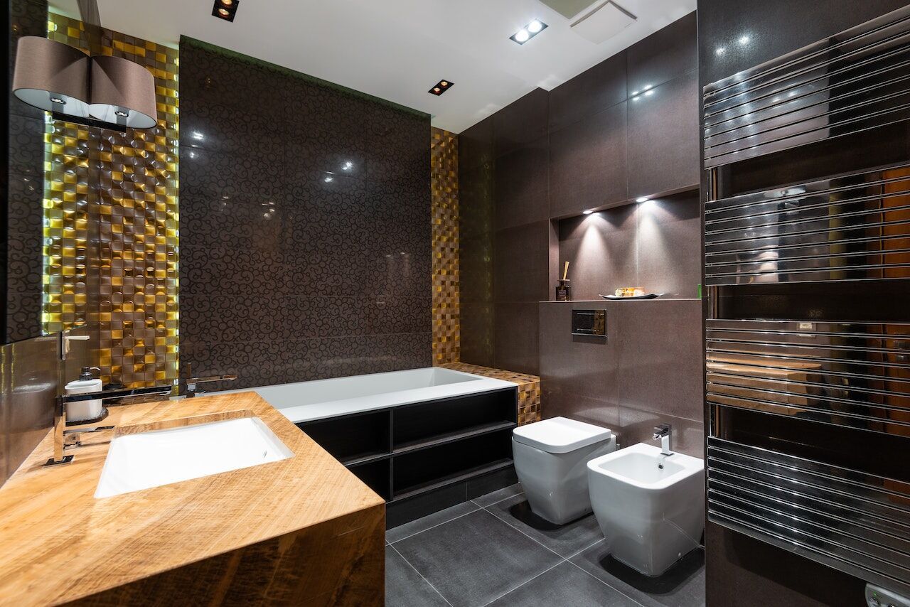 Modern bathroom with wooden countertop, bathtub, and textured tile walls