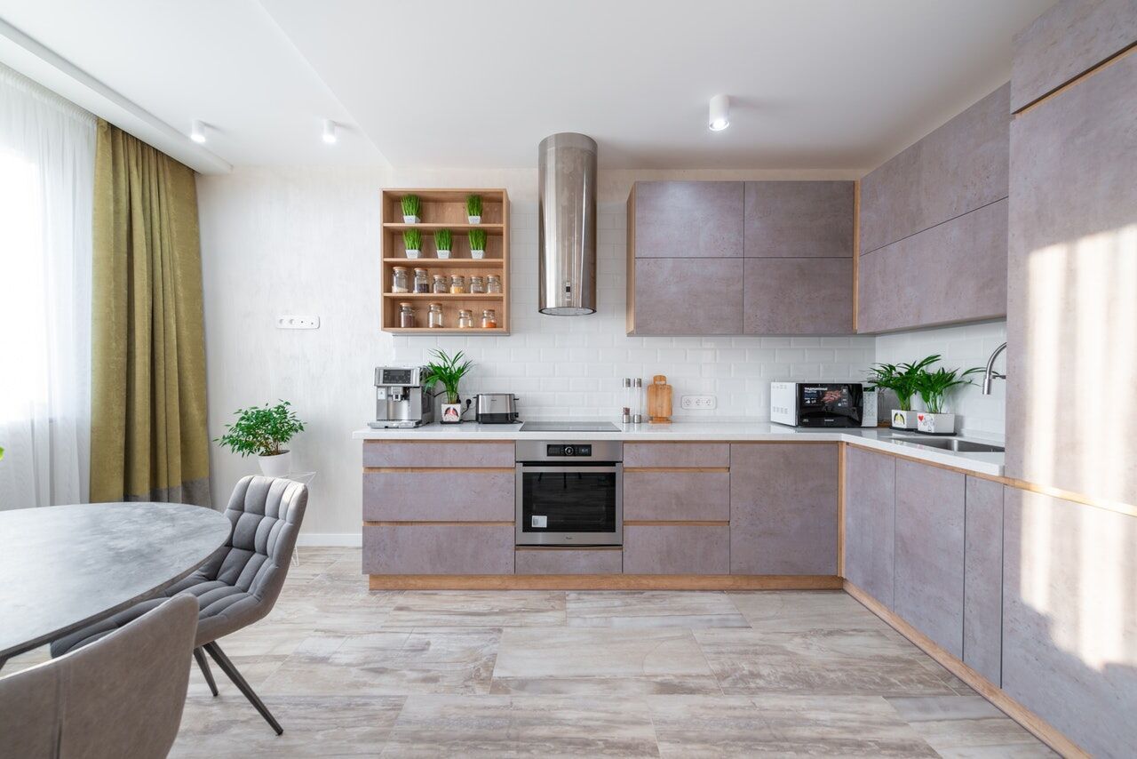 Modern kitchen with gray cabinets, white subway tile backsplash, and dining area