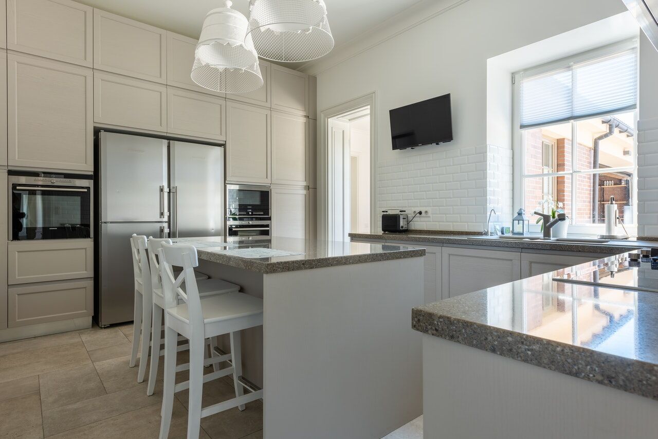 Modern kitchen with granite countertops, white cabinets, and stainless steel appliances