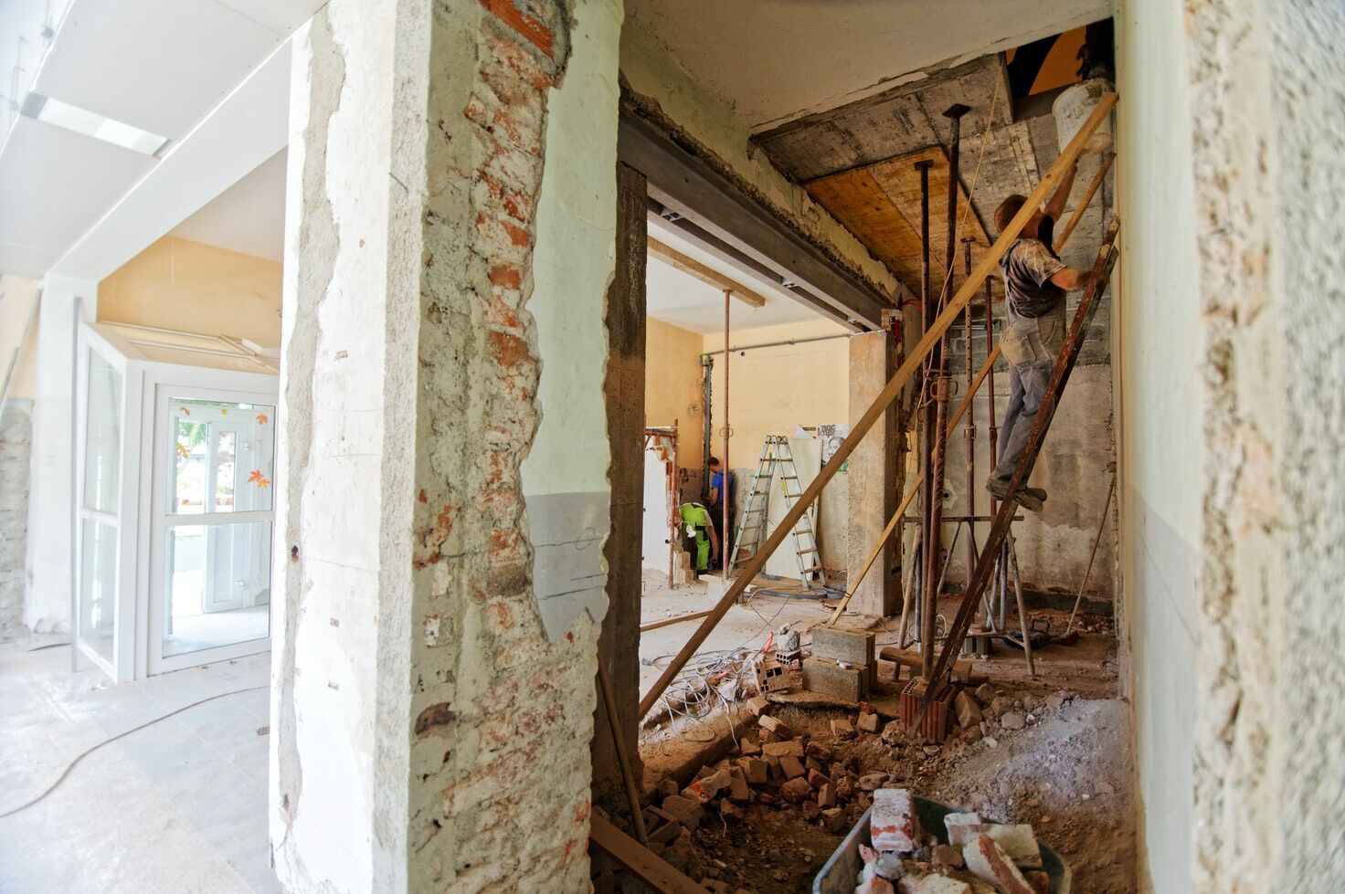 Construction site with exposed walls, scaffolding, and a worker in action