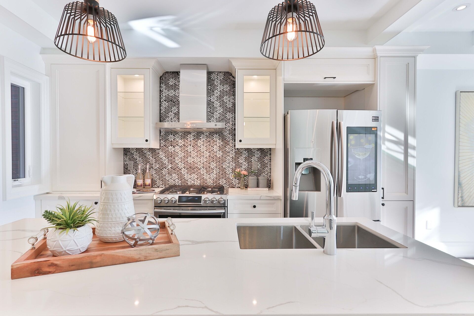 Modern kitchen featuring a white marble countertop, stainless steel appliances, and decorative tile backsplash