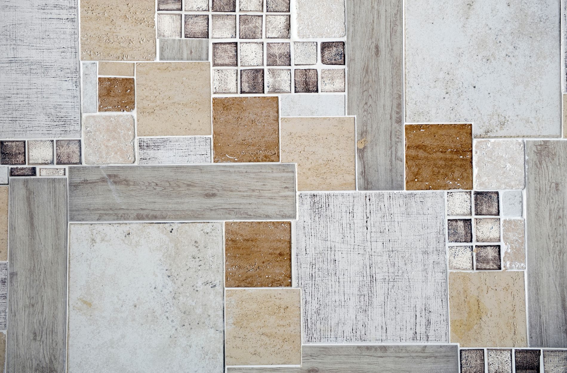 Assorted tiles in various sizes and textures arranged in a layered pattern