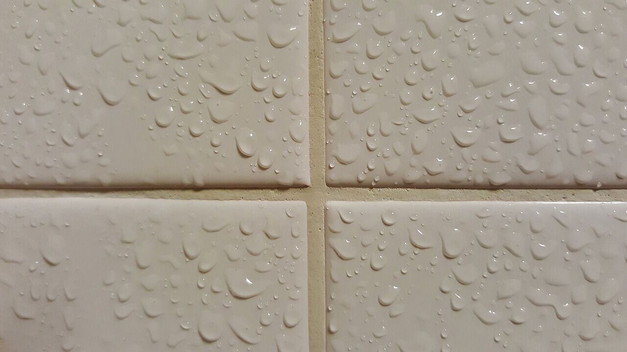 Beige tiles with water droplets showing grout lines in detail