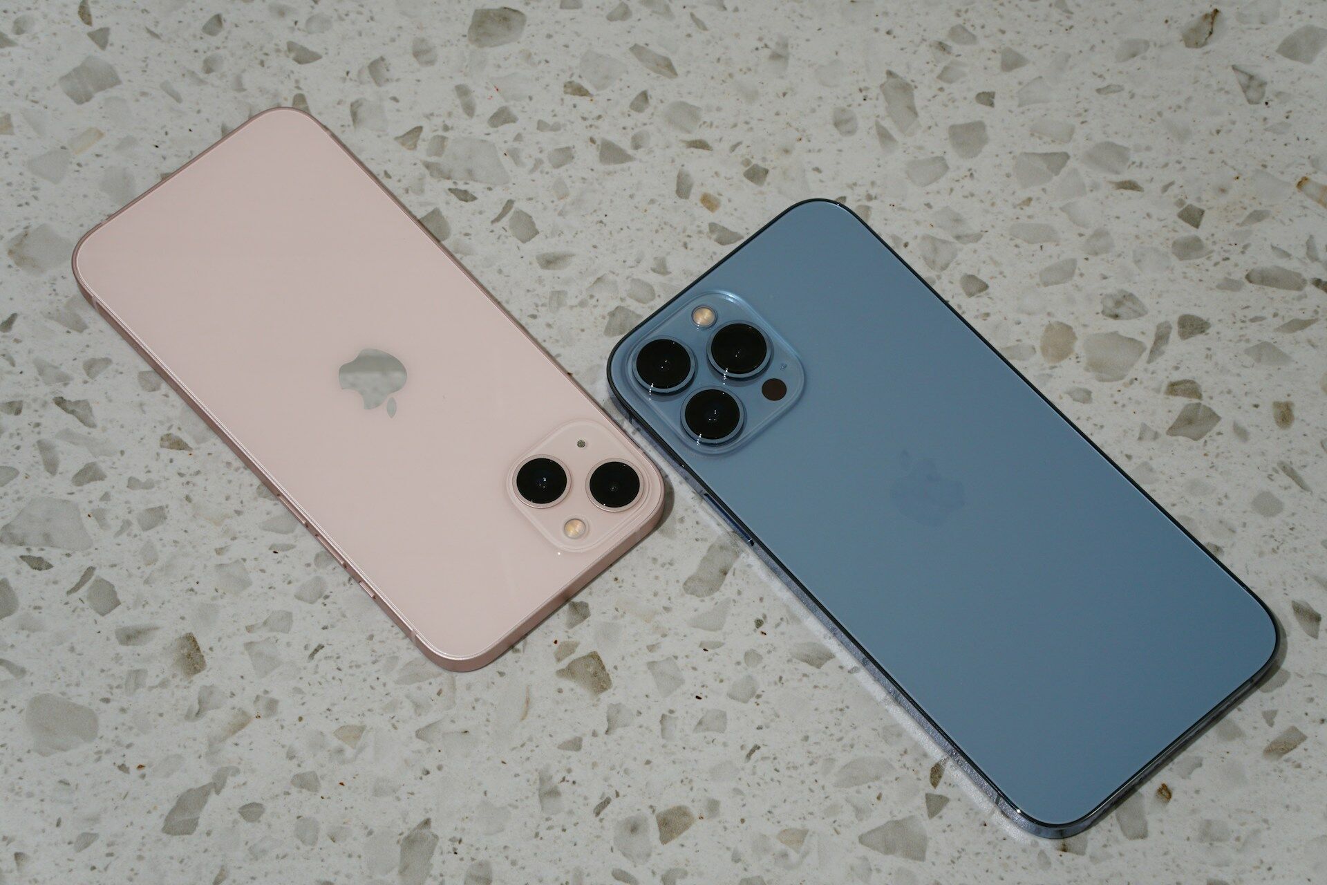 Two smartphones on a terrazzo tile surface, showcasing the tile's texture and pattern
