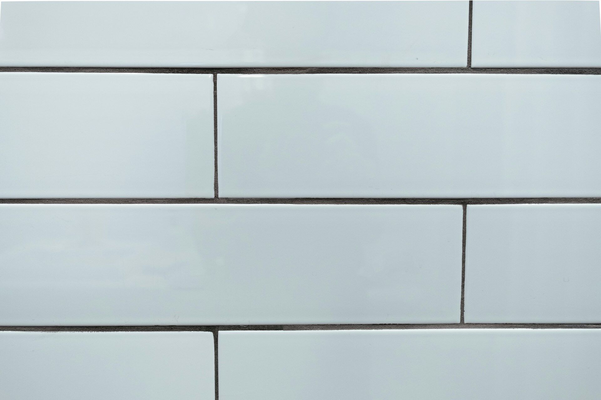 Close-up of white rectangular tiles in a subway pattern with grout lines