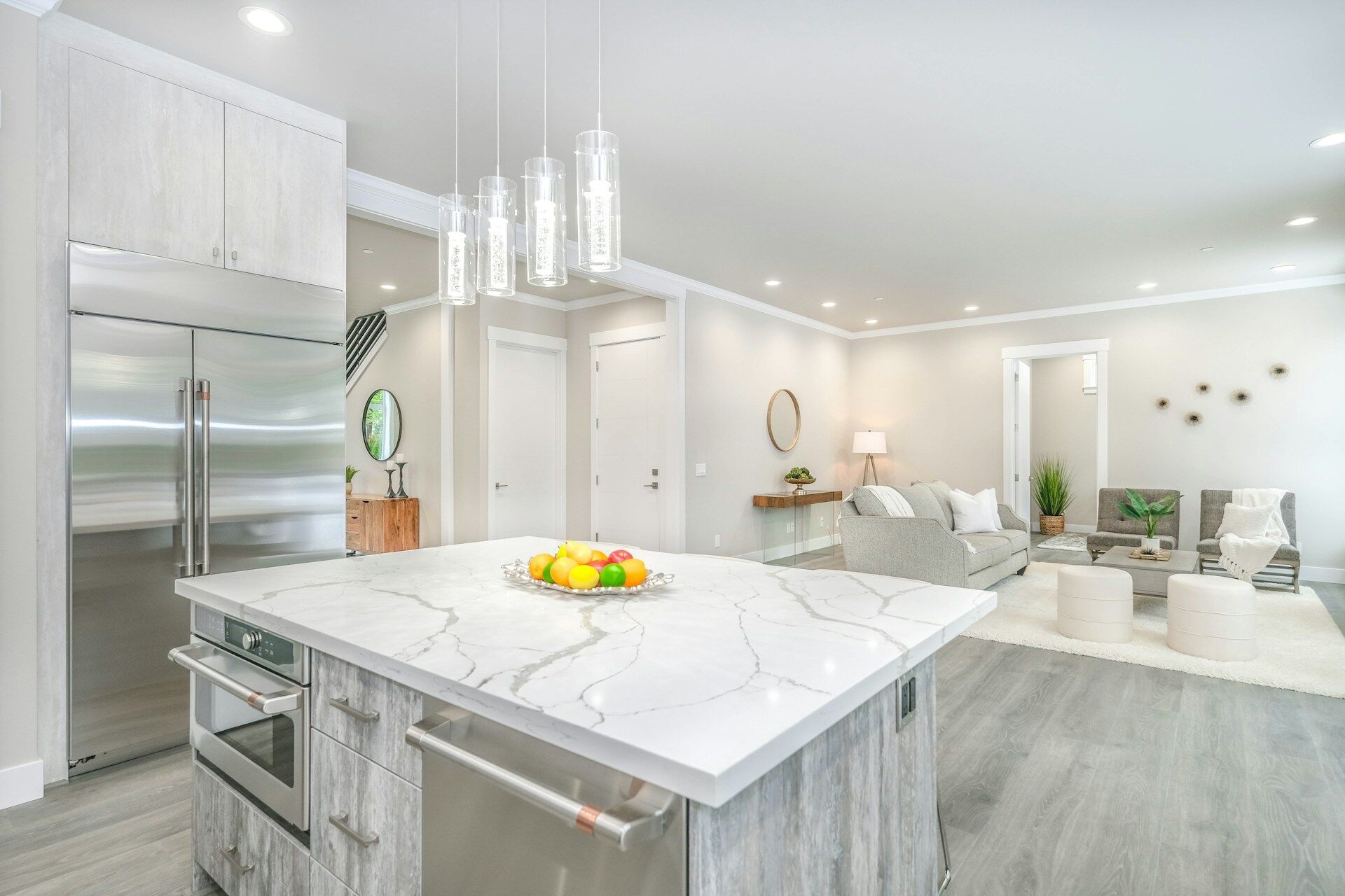 Modern kitchen featuring a marble countertop island and open living area with stylish decor